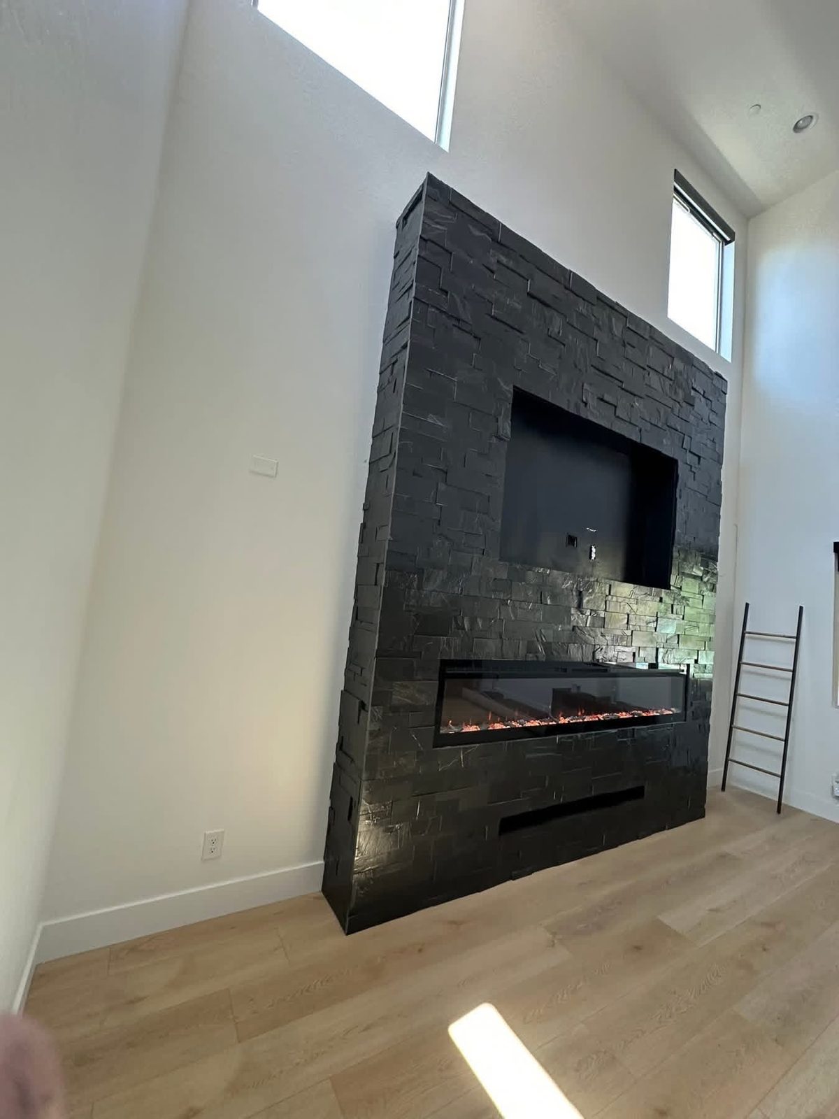 Stone-clad built-in feature wall around a mounted TV.