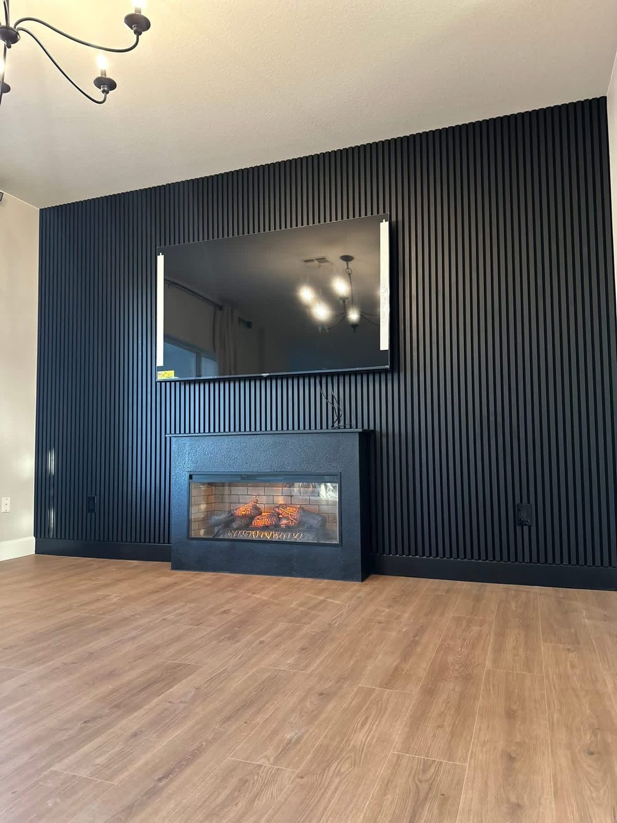 Built-in slat wall paneling around a wall-mounted fireplace.