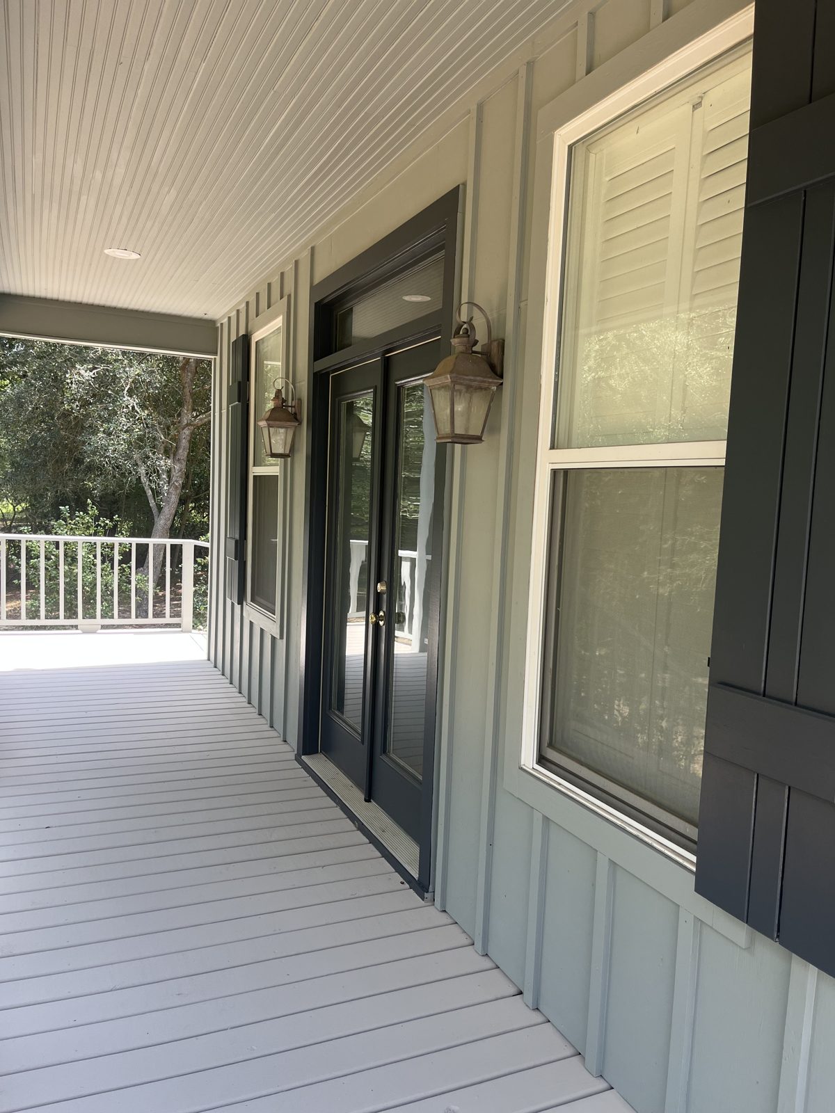 Freshly painted porch trim, shutters, and window casing.