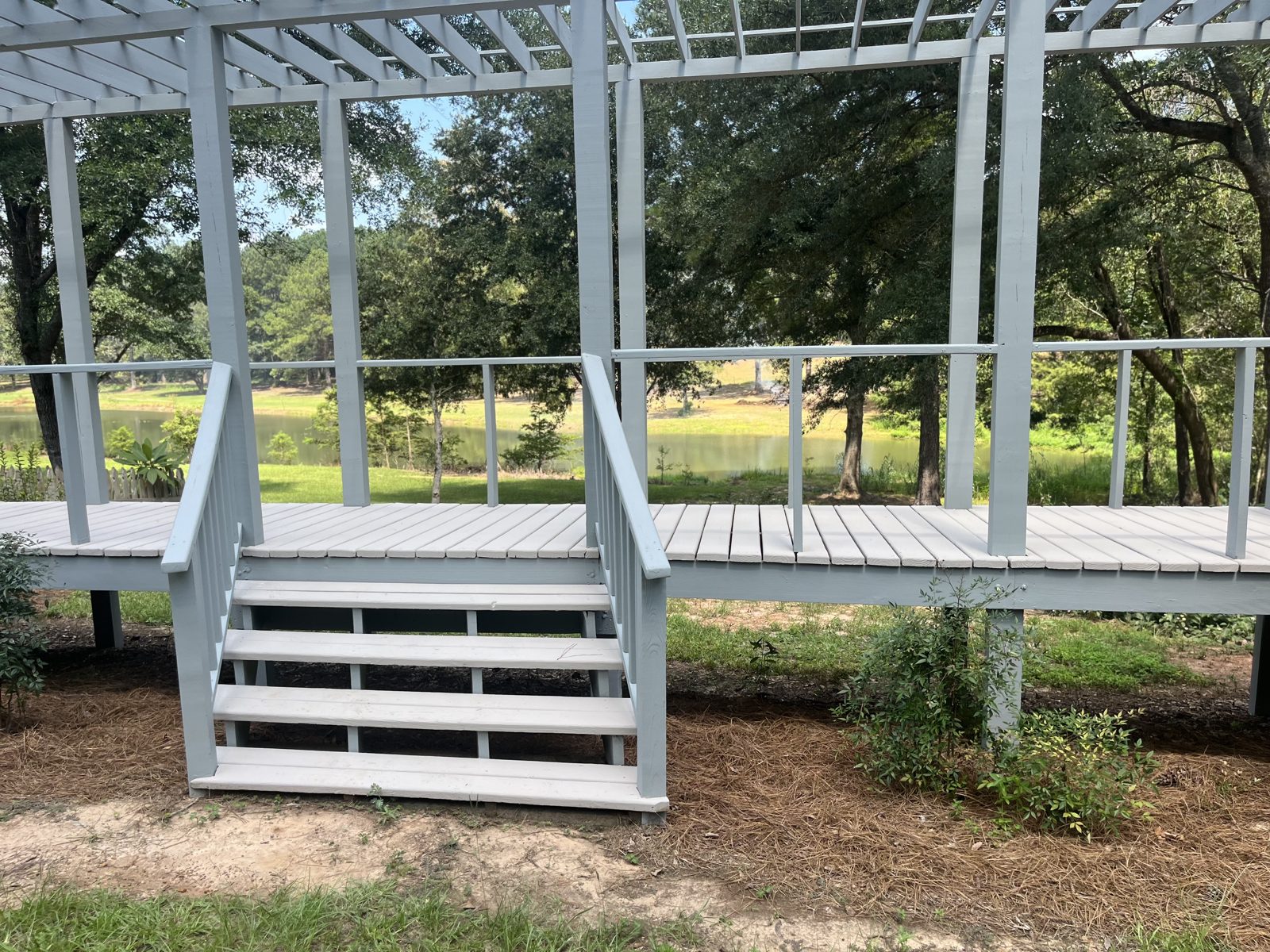 Painted pergola framing and deck stair construction.